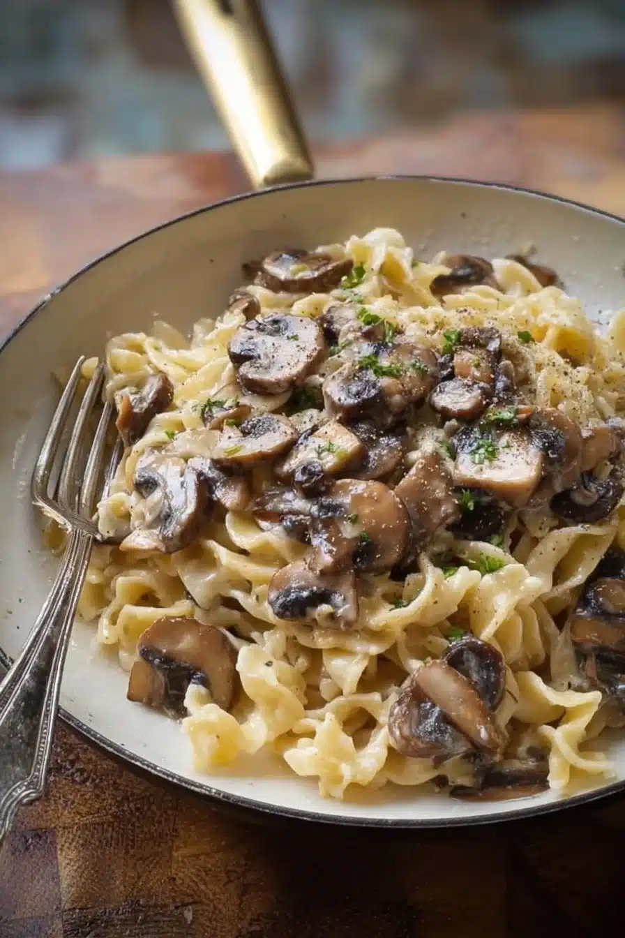 Assiette de pâtes aux champignons garnies de parmesan et persil frais